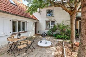 Un patio con una mesa y sillas y un árbol. en „Landidylle Niederlausitz“ – Gemütliches Feriendomizil zwischen Natur und Kultur, en Heideblick