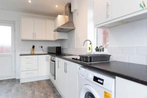 a white kitchen with a sink and a dishwasher at Gilside Lodge in Stockton-on-Tees