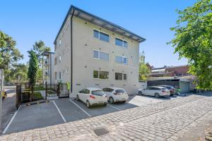 a building with cars parked in a parking lot at Stunning 1-Bed Ground Floor Unit with Front Yard in Melbourne
