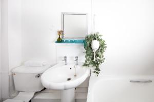 a white bathroom with a sink and a toilet at Fab Arthur Seat Views, Old Town Apartment in Edinburgh