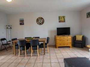 a dining room with a table and chairs and a television at Gîte spacieux au cœur du Périgord - 2 Chambres, Terrasse, Parking - FR-1-616-213 in Saint-Mesmin