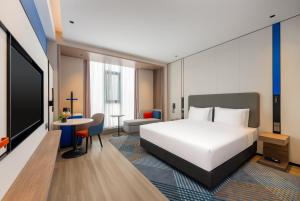 a hotel room with a bed and a table at Holiday Inn Express Liaocheng ETDZ, an IHG Hotel in Liaocheng