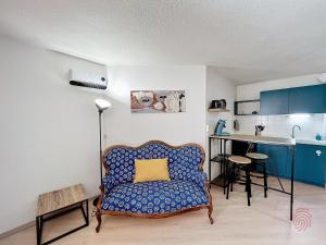 ein Wohnzimmer mit einem Sofa und einer Küche in der Unterkunft Studio Lamalou-les-Bains, 1 pièce, 2 personnes - FR-1-451-207 in Lamalou-les-Bains