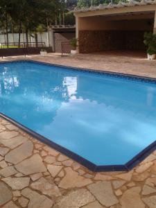 uma piscina com água azul num quintal em Espaço lerri (chácara completa e muito ampla) em Ribeirão Preto