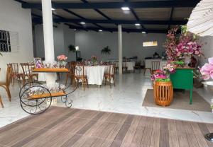 duży pokój ze stołami, krzesłami i kwiatami w obiekcie Chácara R e A eventos w mieście Uberlândia