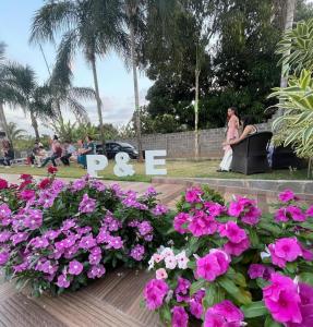 grupa ludzi siedzących w parku z kwiatami w obiekcie Chácara R e A eventos w mieście Uberlândia