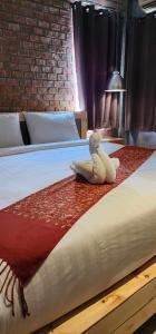 a stuffed animal is sitting on a bed at Unotel Karon Beach in Karon Beach