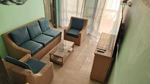 uma sala de estar com um sofá, cadeiras e uma mesa em Apartamento 1403 Edificio Karey El Rodadero em Santa Marta