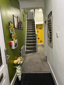 a hallway with a staircase with a vase of flowers at Quirky Oasis Anfield in Liverpool