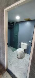 a bathroom with a toilet and a glass shower at Unotel Karon Beach in Karon Beach