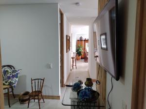 a living room with a television and a hallway at HABITACION NOVA CONDOMINIO PLUS CALI in Cali