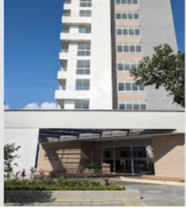 a large white building with two tall buildings in the background at HABITACION NOVA CONDOMINIO PLUS CALI in Cali