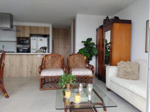 a living room with two chairs and a table at HABITACION NOVA CONDOMINIO PLUS CALI in Cali
