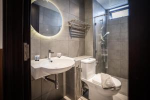 bagno con lavandino, servizi igienici e specchio di K Avenue by Pinstay a Donggongon