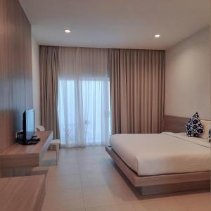 Baanfah Resort Samui في شاطئ مينام: غرفة نوم بسرير وتلفزيون ونافذة