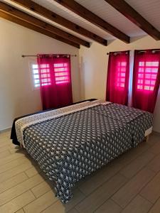 a bedroom with two red windows and a bed at Villa titwoine in Pointe-Noire