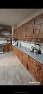an empty kitchen with wooden cabinets and appliances at مزرعة كراون in Umm el ‘Amad