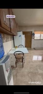 a kitchen with a table and a chair and a refrigerator at مزرعة كراون in Umm el ‘Amad