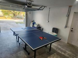 una mesa de ping pong con una raqueta de ping pong. en Drift House - 4Bed 3Bath Private Pool House, en Cabo Cañaveral