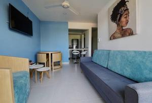 a living room with a blue couch and a television at The Refuge#1 Lovely 2 BR-Apt pool & good vibes in Santa Marta