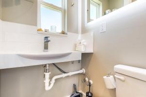 a white bathroom with a sink and a mirror at Beach 5 Villas #B1 in Fernandina Beach