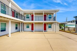 uma casa com portas vermelhas e uma varanda em Beach 5 Villas #B1 em Fernandina Beach