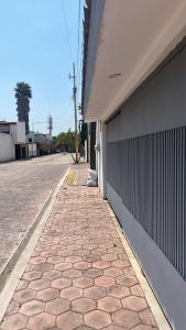um passeio de tijolos ao lado de um edifício numa rua em La Casa del Agua Puebla em Acatepec