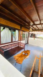 uma sala de estar com uma mesa de madeira e um sofá em Balangan Sea View Bungalow em Jimbaran