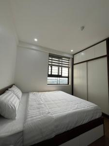 a bedroom with a white bed and a window at Mami House - Tecco Elite City Thai Nguyen Serviced Apartments in Thái Nguyên