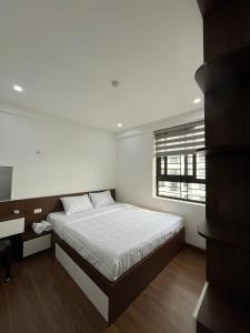 a white bedroom with a bed and a window at Mami House - Tecco Elite City Thai Nguyen Serviced Apartments in Thái Nguyên