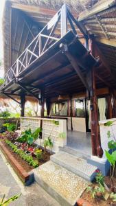 金巴蘭的住宿－Balangan海景簡易別墅，一座有蓝色屋顶的建筑,上面有一堆植物