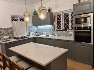 a kitchen with gray cabinets and a white counter top at Luxury villa with chef/bartender - La Cosa Nostra in Colva