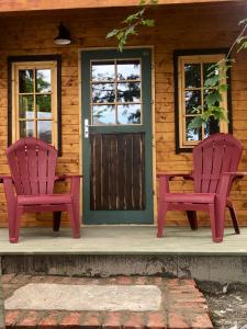 2 chaises assises sur la terrasse couverte avant d'une cabine dans l'établissement Funky Bunky, à Nelson