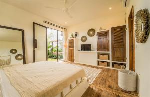 a bedroom with a bed and a large window at Villa Kosibali by Optimum Bali Villas in Kerobokan