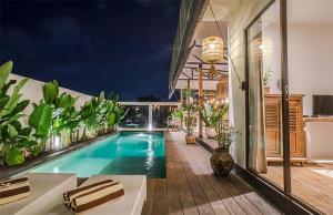 a swimming pool in the middle of a house at Villa Kosibali by Optimum Bali Villas in Kerobokan