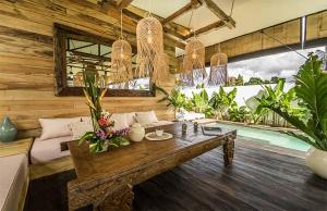a living room with a table and a pool at Villa Kosibali by Optimum Bali Villas in Kerobokan