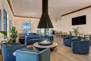 a living room with blue chairs and a fireplace at The Dunes Hotel (Palm Springs) in Palm Springs
