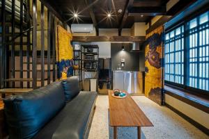 a living room with a leather couch and a wooden table at Asagi an Machiya House in Kyoto