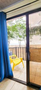 a room with a view of the beach through a sliding glass door at Pura Vida Macaw Paradise in Jacó