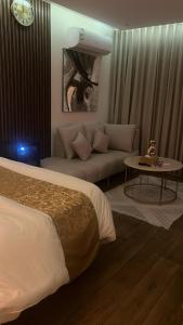 a hotel room with a bed and a couch at ستديو فخم مجاور البولي فارد بلكونه in Riyadh