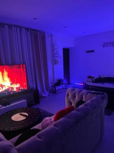 ein Wohnzimmer mit einem Kamin und einem Sofa in der Unterkunft Deluxe appartement Jacuzzi in Freneuse