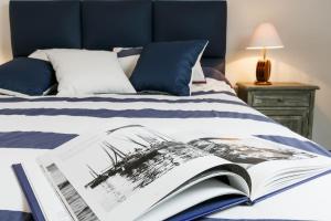 un livre ouvert sur un lit avec une tête de lit bleue dans l'établissement La fringante, à Pleubian