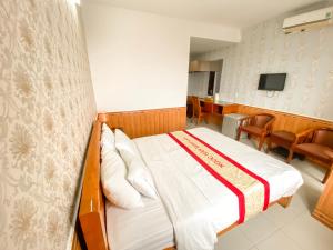 a hotel room with a bed and a dining room at Ngọc Hân Hotel By The Moment in Vung Tau