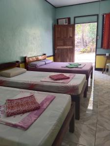 a group of four beds in a room at Xylla Guesthouse in Siquijor