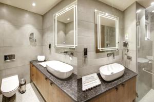 a bathroom with two sinks and two toilets at Saltstayz Sage - Near Golf Course Road in Gurgaon
