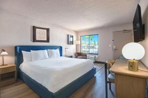 una camera d'albergo con letto e finestra di The Dunes Hotel (Palm Springs) a Palm Springs