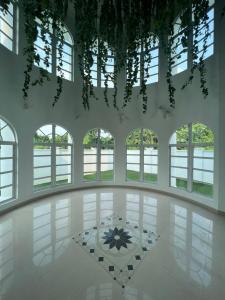 a large room with windows and a white floor at DeGarden House Klang in Klang