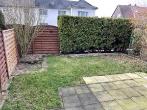 a backyard with a fence and a yard withgrass at Wunderschönes Haus mit Garten für 10 Personen in Hannover