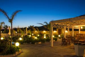 a patio with tables and chairs and lights at night at Villa Delle Palme Delfina in Trapani