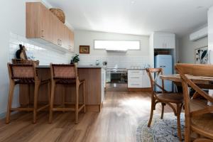 eine Küche mit Holzstühlen und einem Tisch im Zimmer in der Unterkunft Bluebell Cottage in Invermay